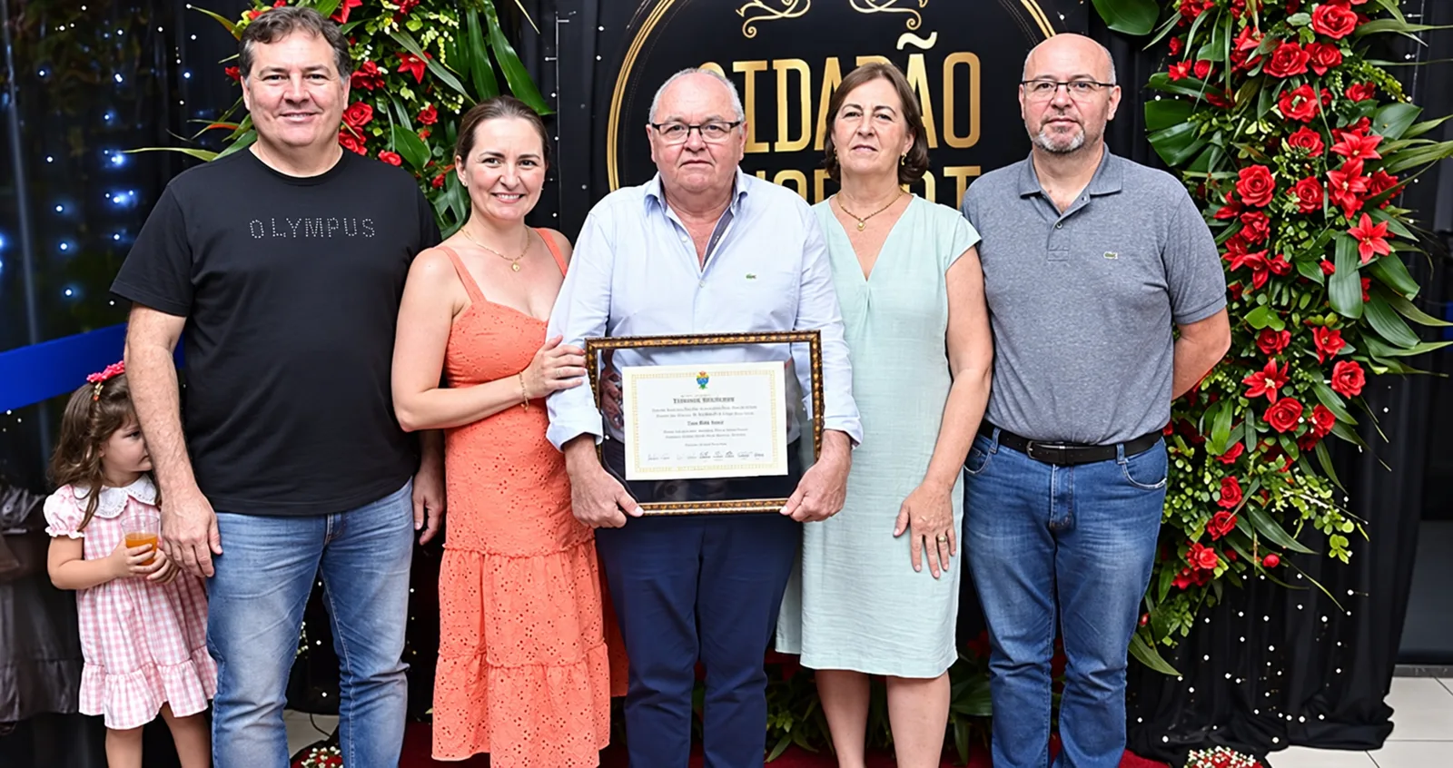 Ênio, fundador da Casa dos Pneus, segura o diploma de Cidadão Honorário de Nova Mutum ao lado de familiares